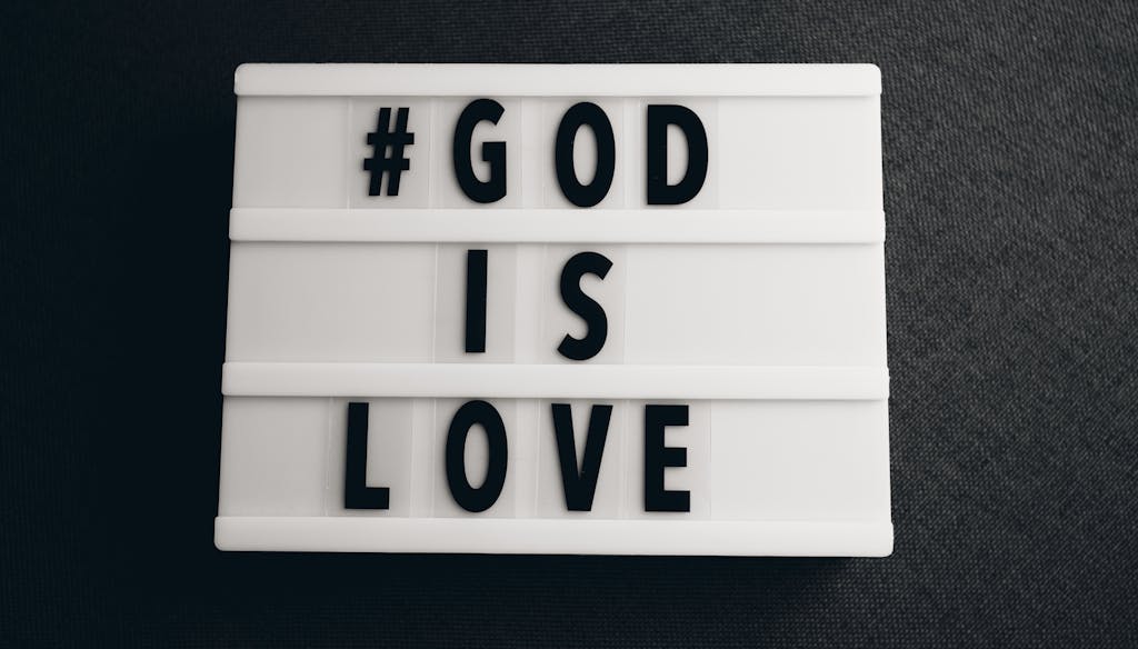 Lightbox with the message '#GOD IS LOVE' on a gray background, inspirational text.