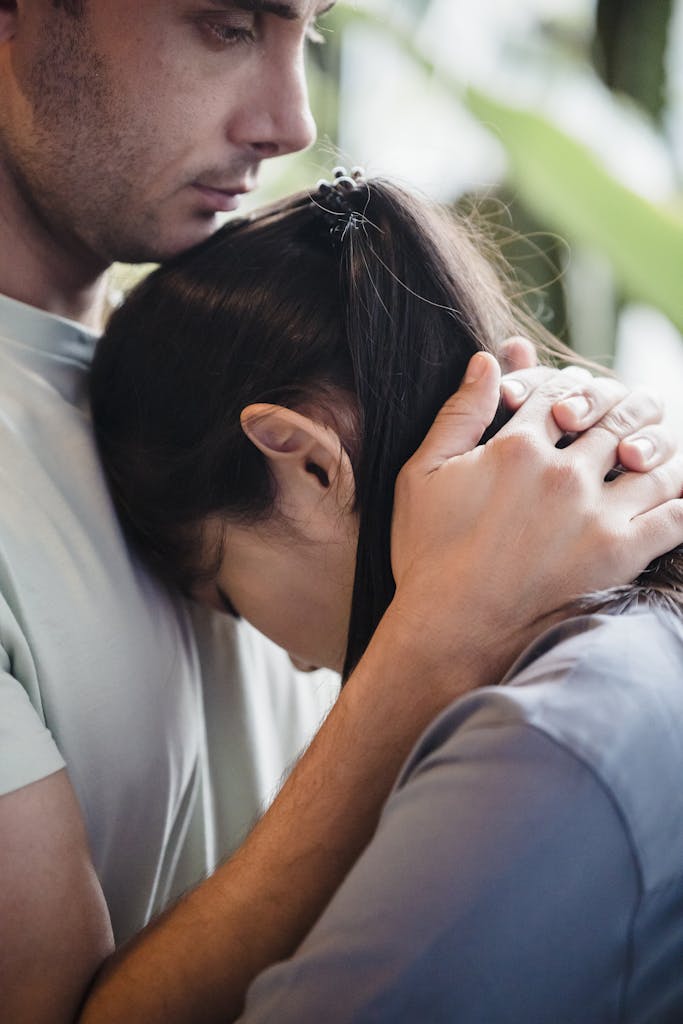 A man and woman embrace tenderly, conveying support and empathy.