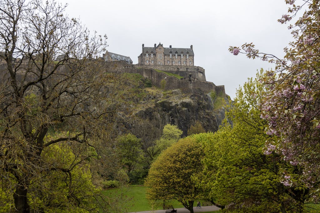 A scenic view of Edinburgh Castle surrounded by spring bloom and greenery.