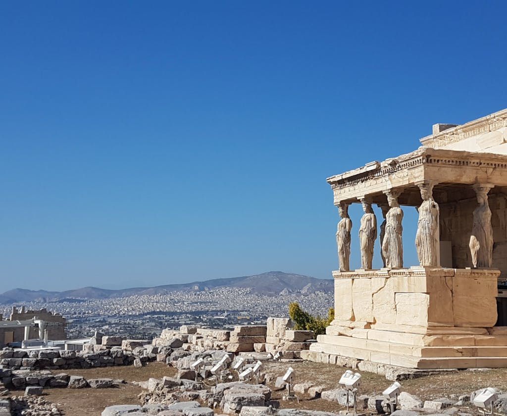 Erechtheion Temple with Caryatids in Acropolis, Athens under a clear blue sky.