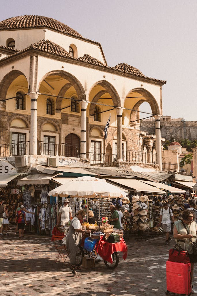 Explore a bustling market in Athens, Greece, with traditional architecture and lively crowds.