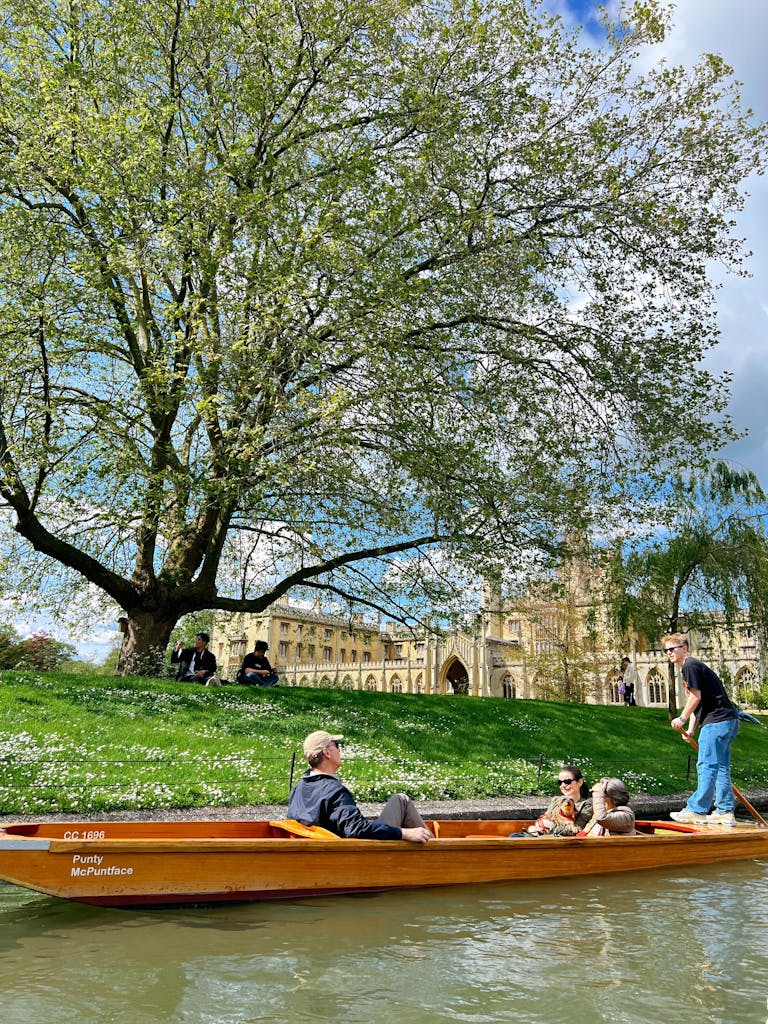 Tranquil scenery of punting on River Cam near historic Cambridge landmarks.