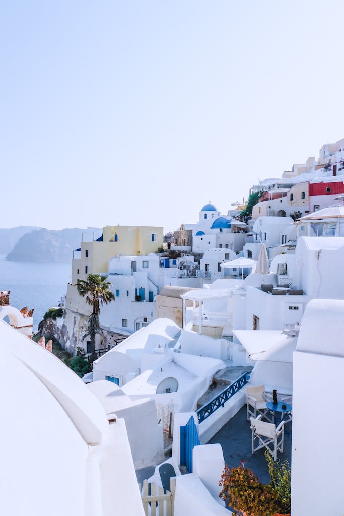 Picturesque white buildings and blue domes in Santorini, Greece under a clear sky.