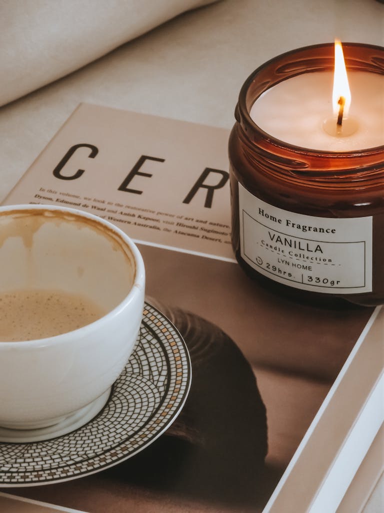 Warm coffee with a vanilla scented candle creating a relaxing ambiance.