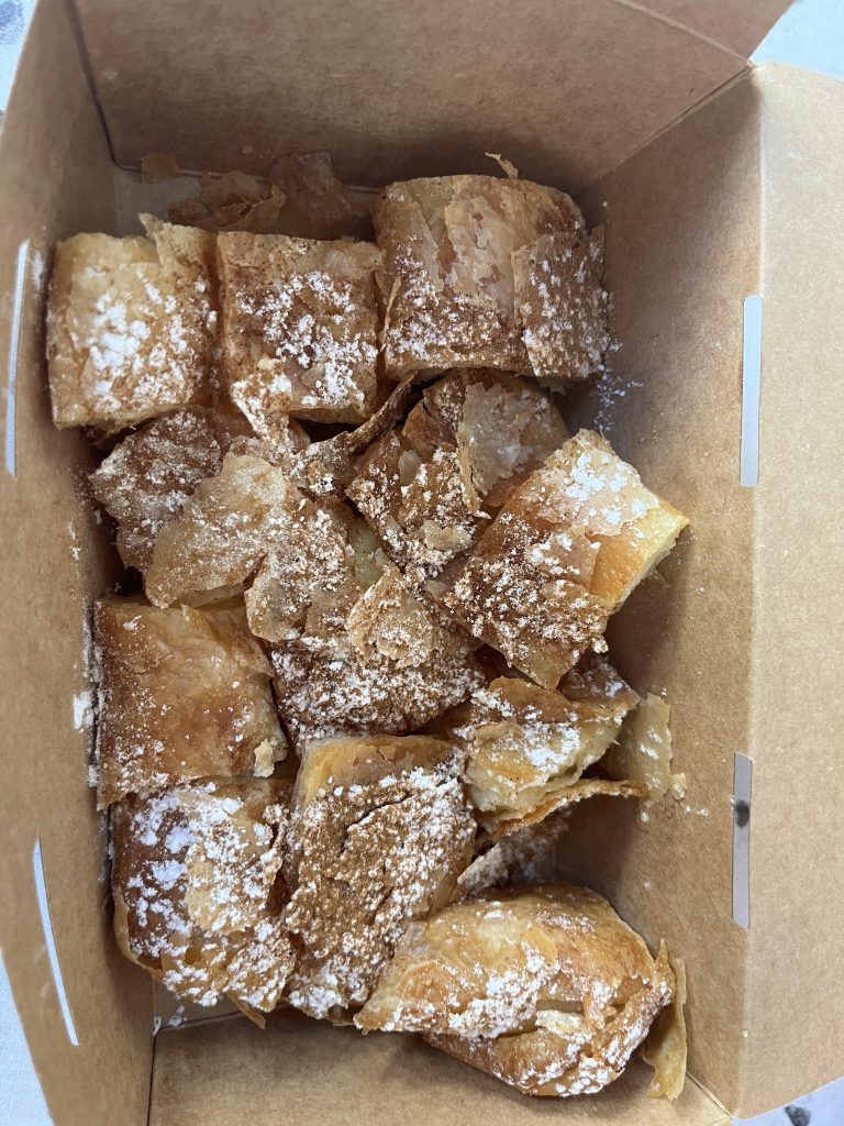 Delicious bougatsa filled with creamy custard and dusted with powdered sugar.