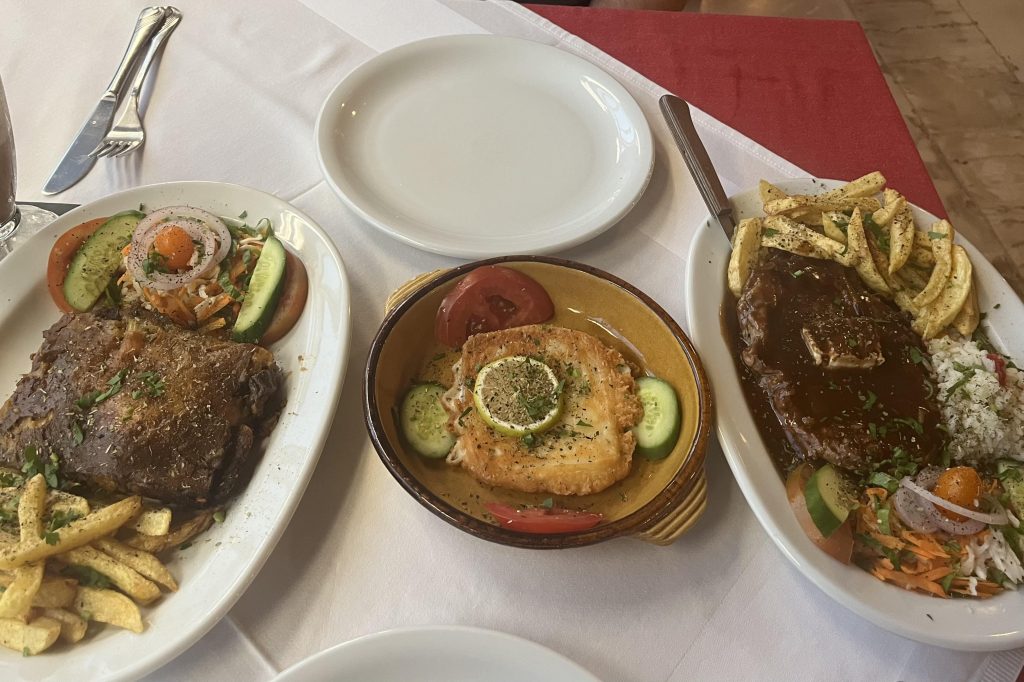 Delicious family style meal at Aris Marie a traditional Greek taverna in Rethymno. Moussaka, Lamb and fish.