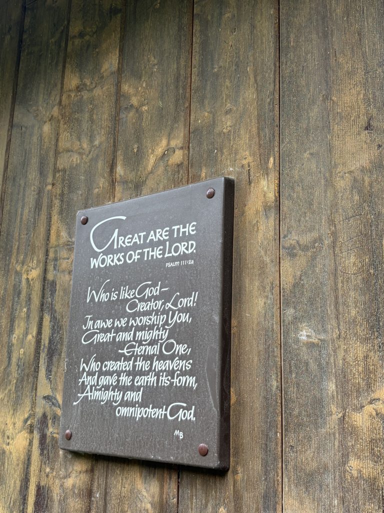 A wooden plaque with Bible scripture written on it.